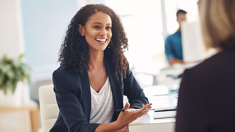 Smiling speech therapist meeting with client at her office.