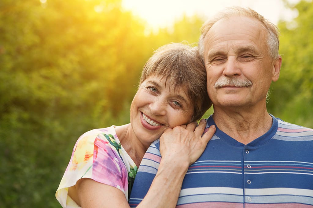 Female mature adult lovingly resting her head on the shoulder of her spouse