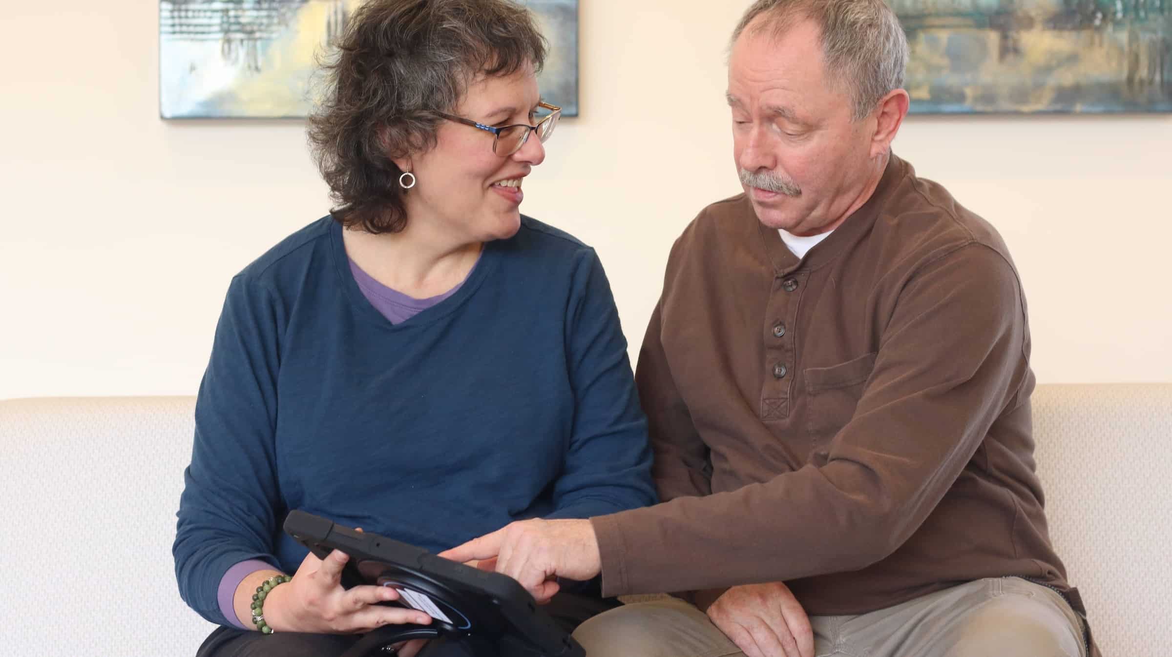 Man uses his Lingraphica AAC device to tell his wife where they should go for lunch.