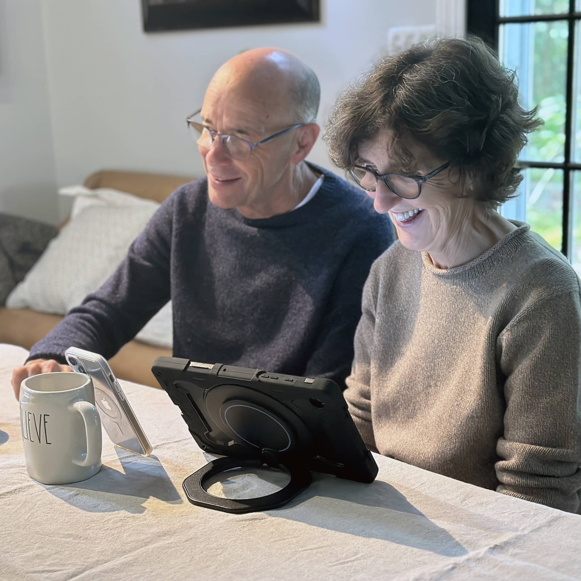 Woman uses her Lingraphica AAC device to communicate while video chatting with her son.