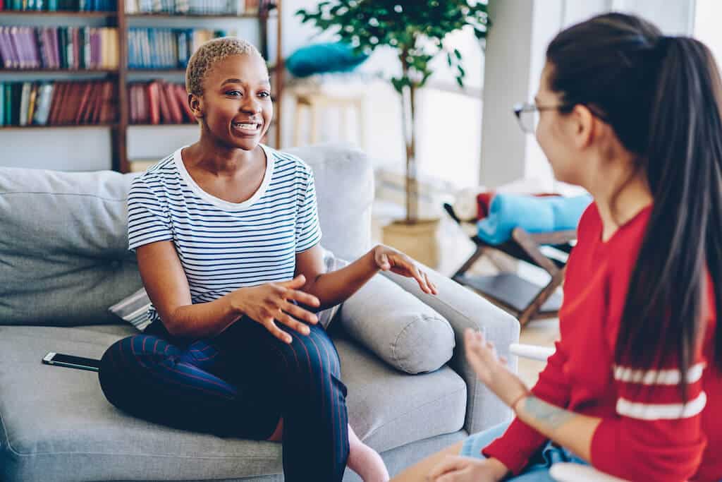 two young women having a conversation indoors