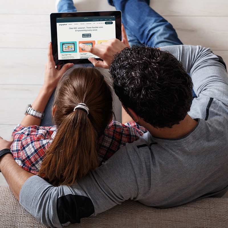 Bird's-eye photo of couple browsing Lingraphica's website on a tablet.