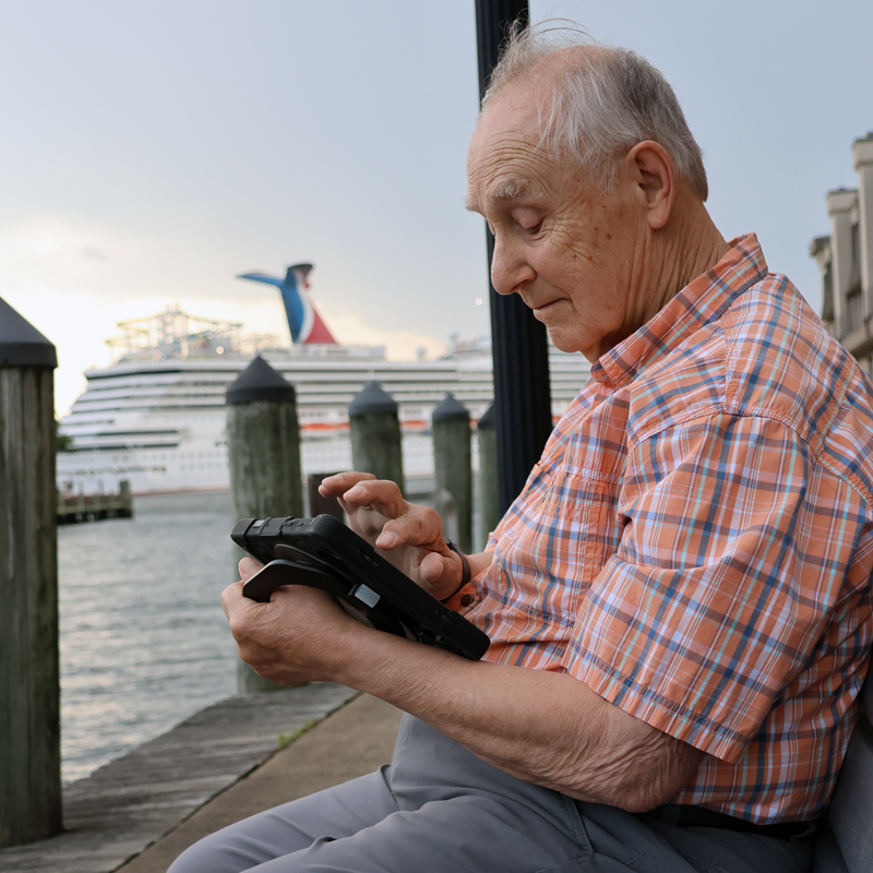 Man using TouchTalk™ AAC device while traveling.