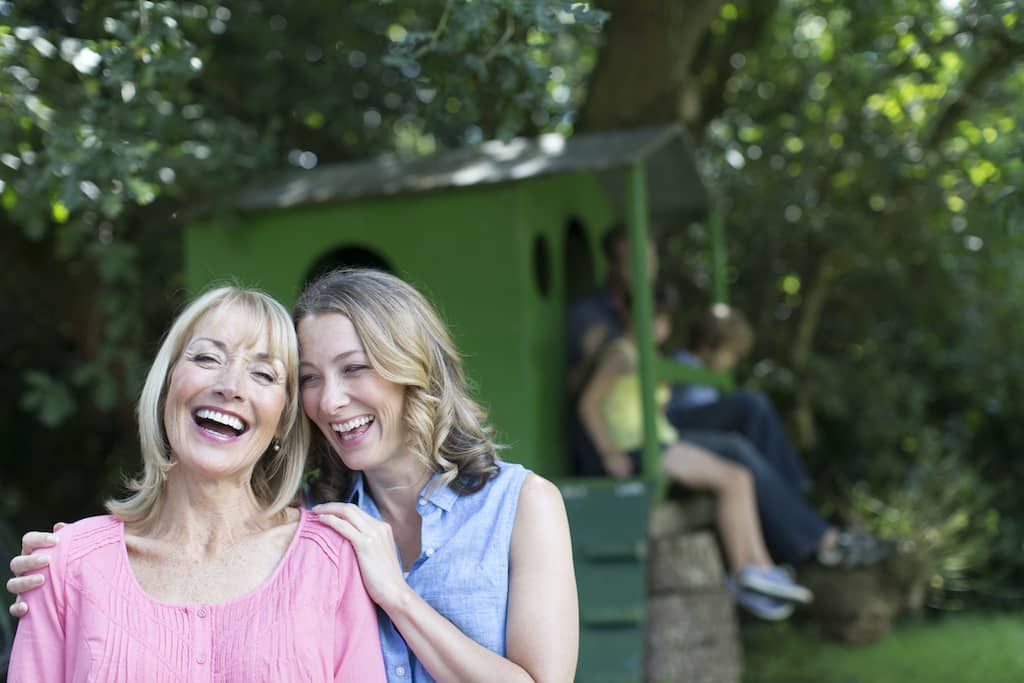 Portrait happy mother and daughter with family at treehouse