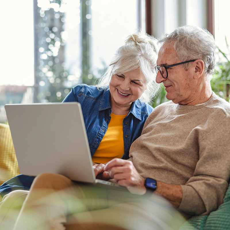 Photo of couple using a laptop at home.