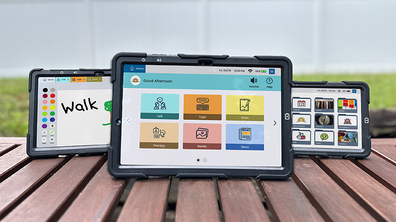 Three Lingraphica devices sitting on a table showing the different communication apps on their screens.