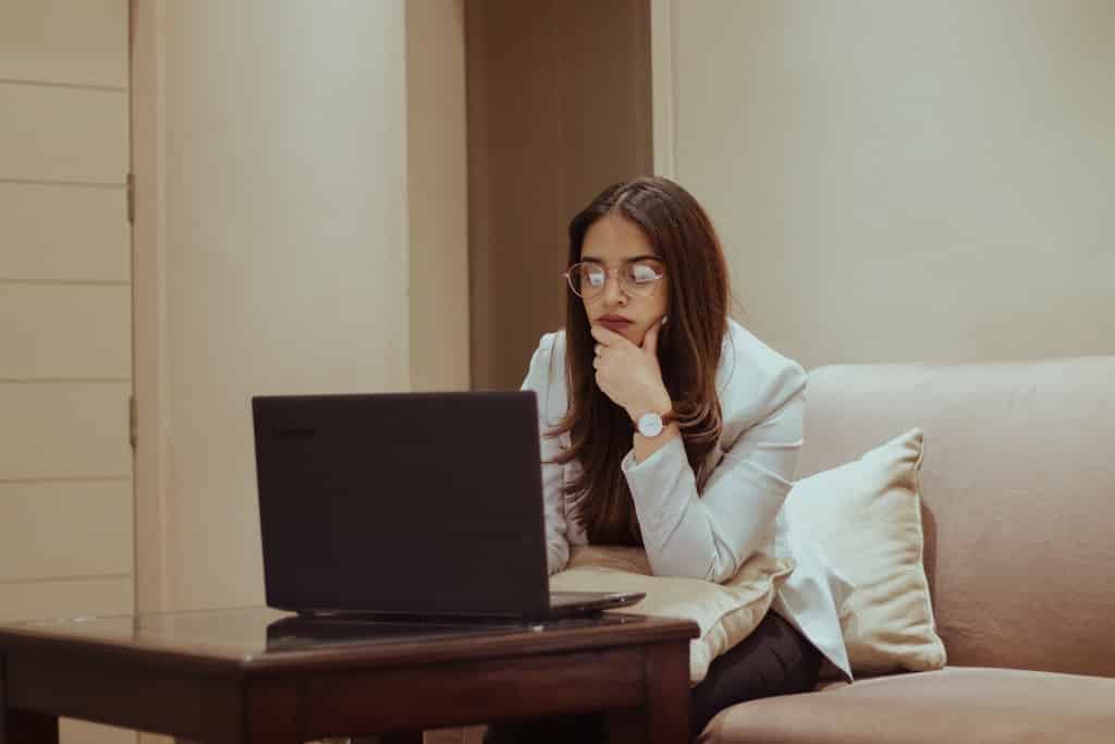 woman on couch looking at laptop